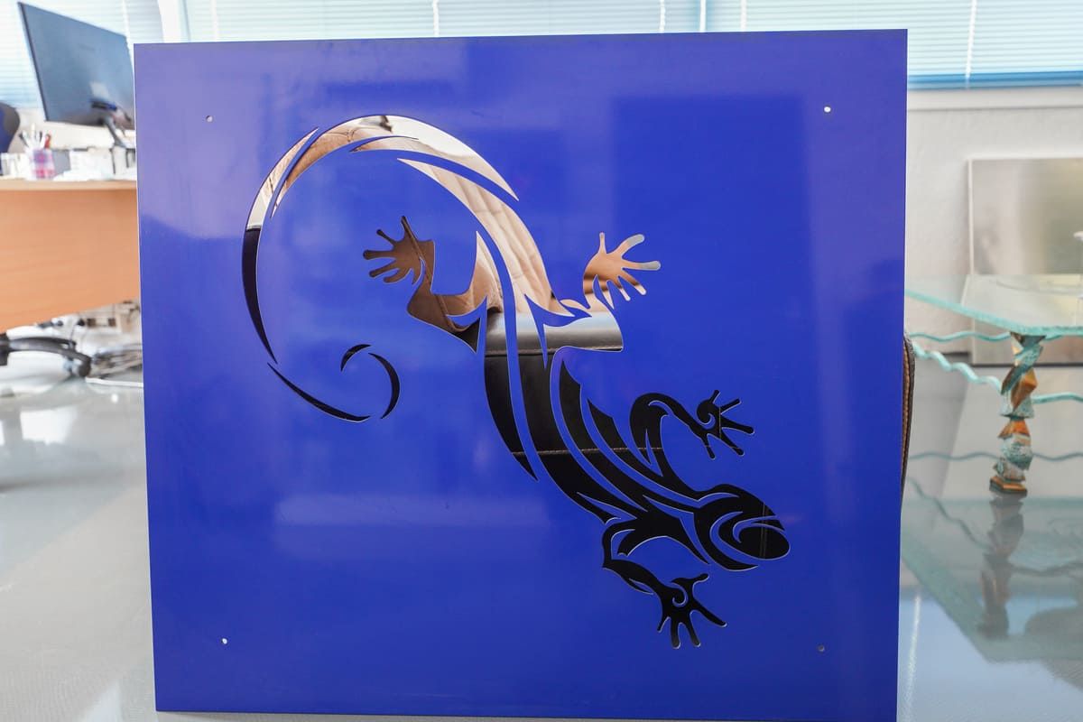 Autocollant silhouette de gecko noir sur un panneau de verre bleu vif