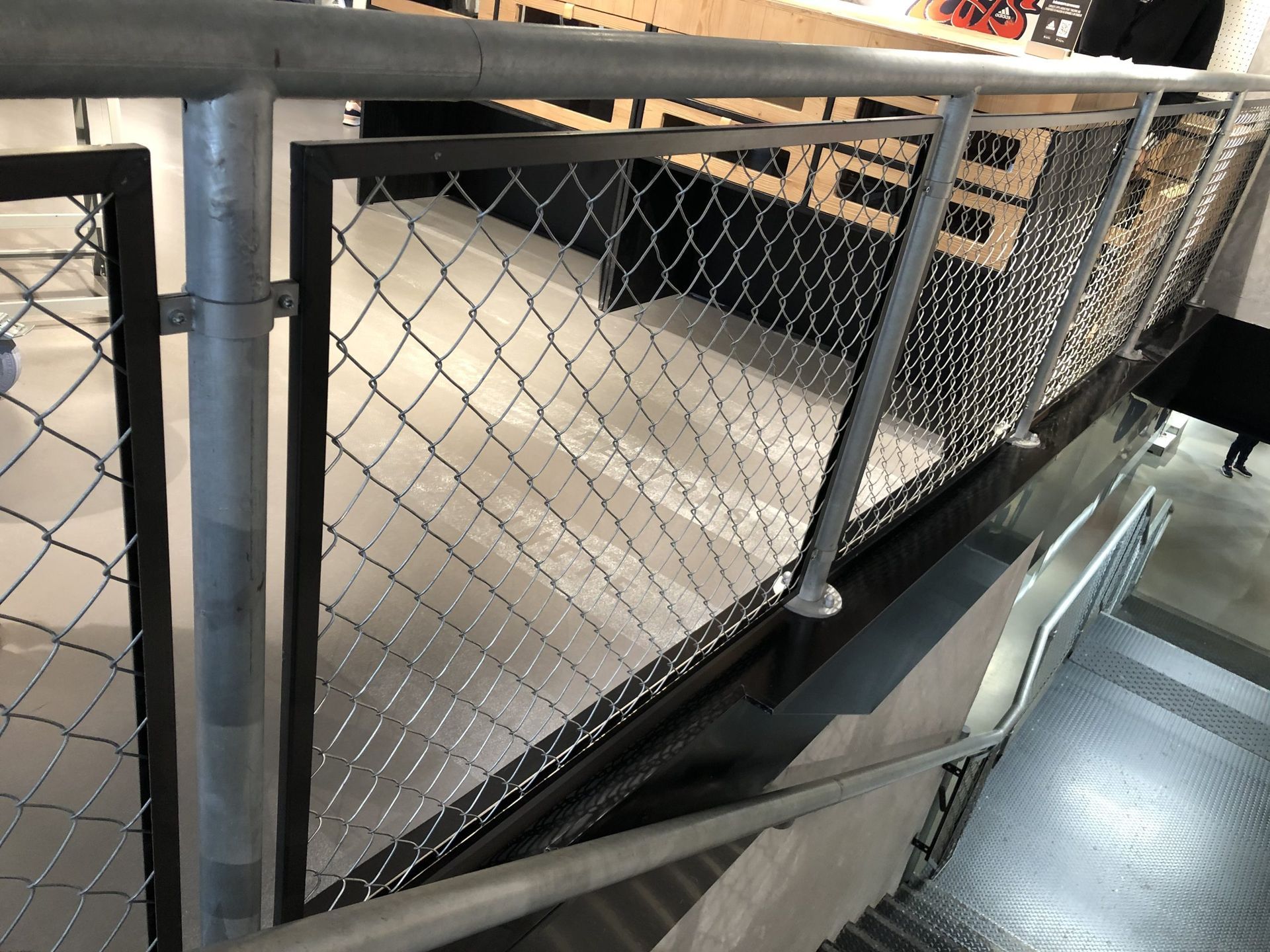 Escalier grillagé et passerelle métallique dans un intérieur industriel.