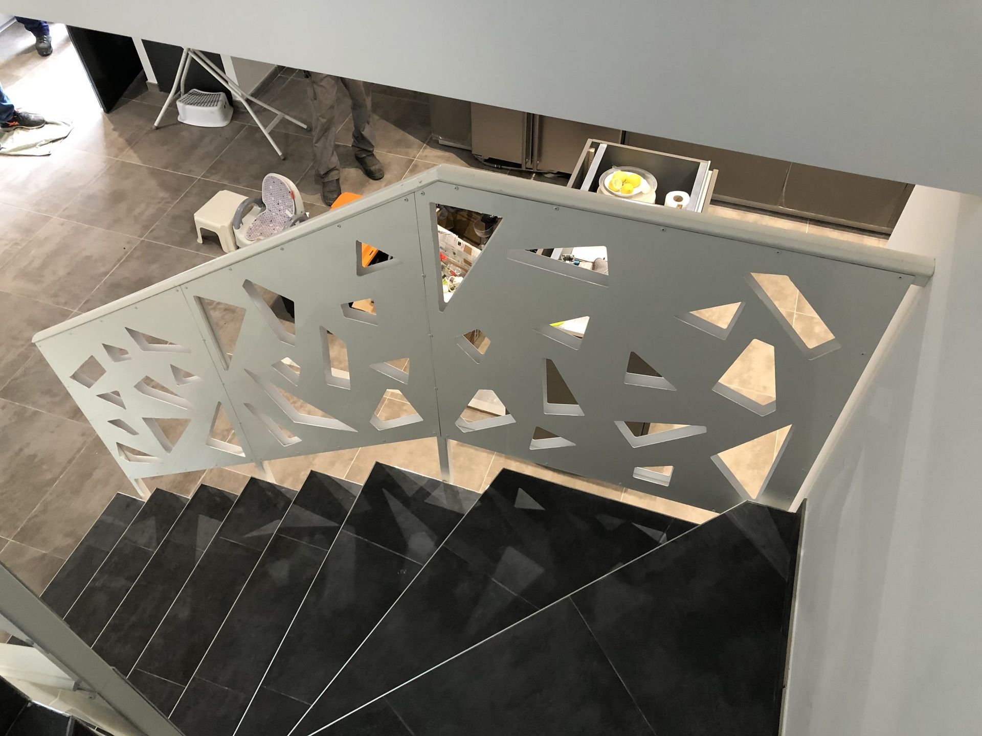 Rambarde géométrique blanche à côté d'un escalier noir dans un espace intérieur