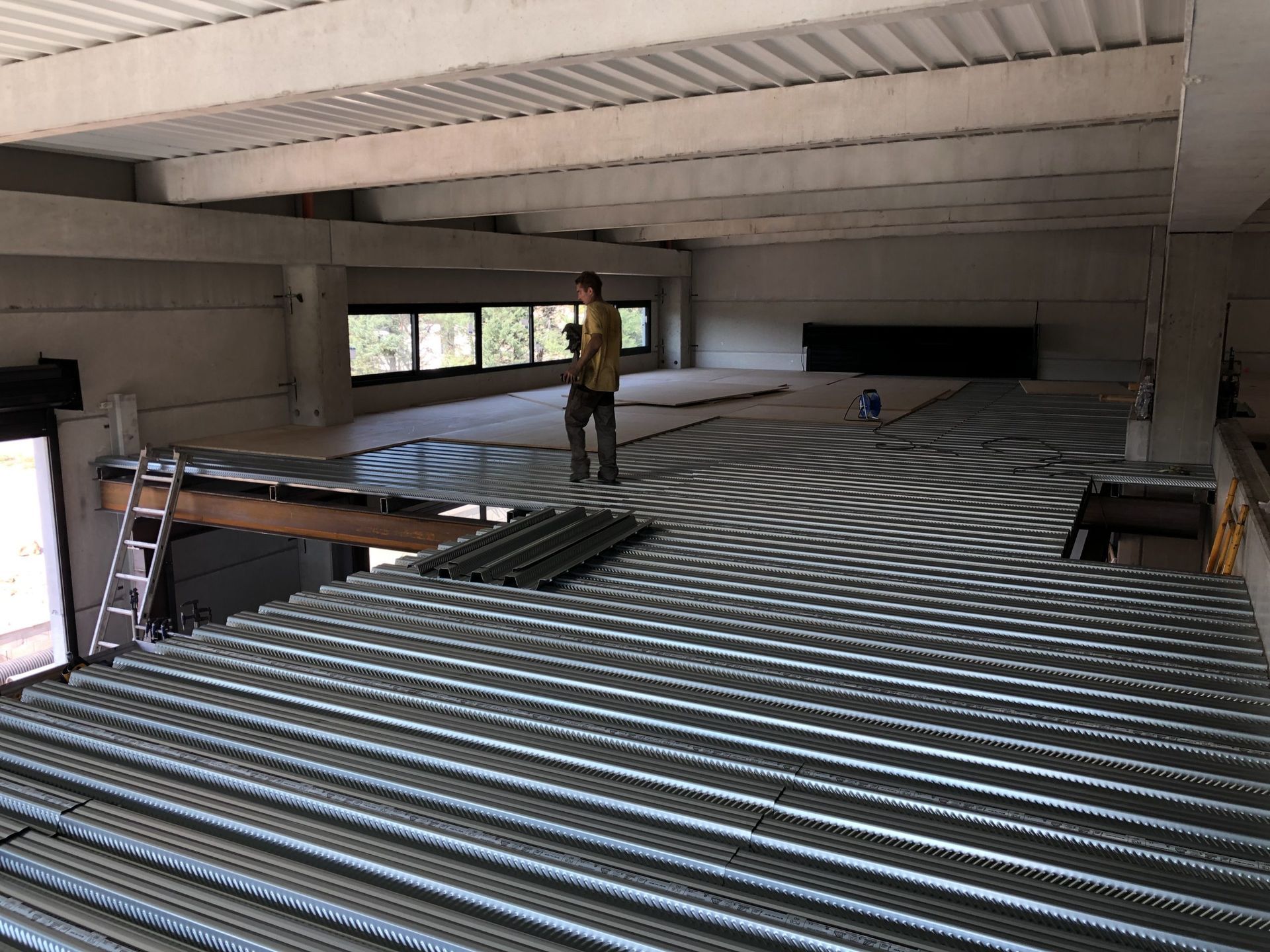 Grand espace intérieur avec une personne debout sur un toit rayé en construction