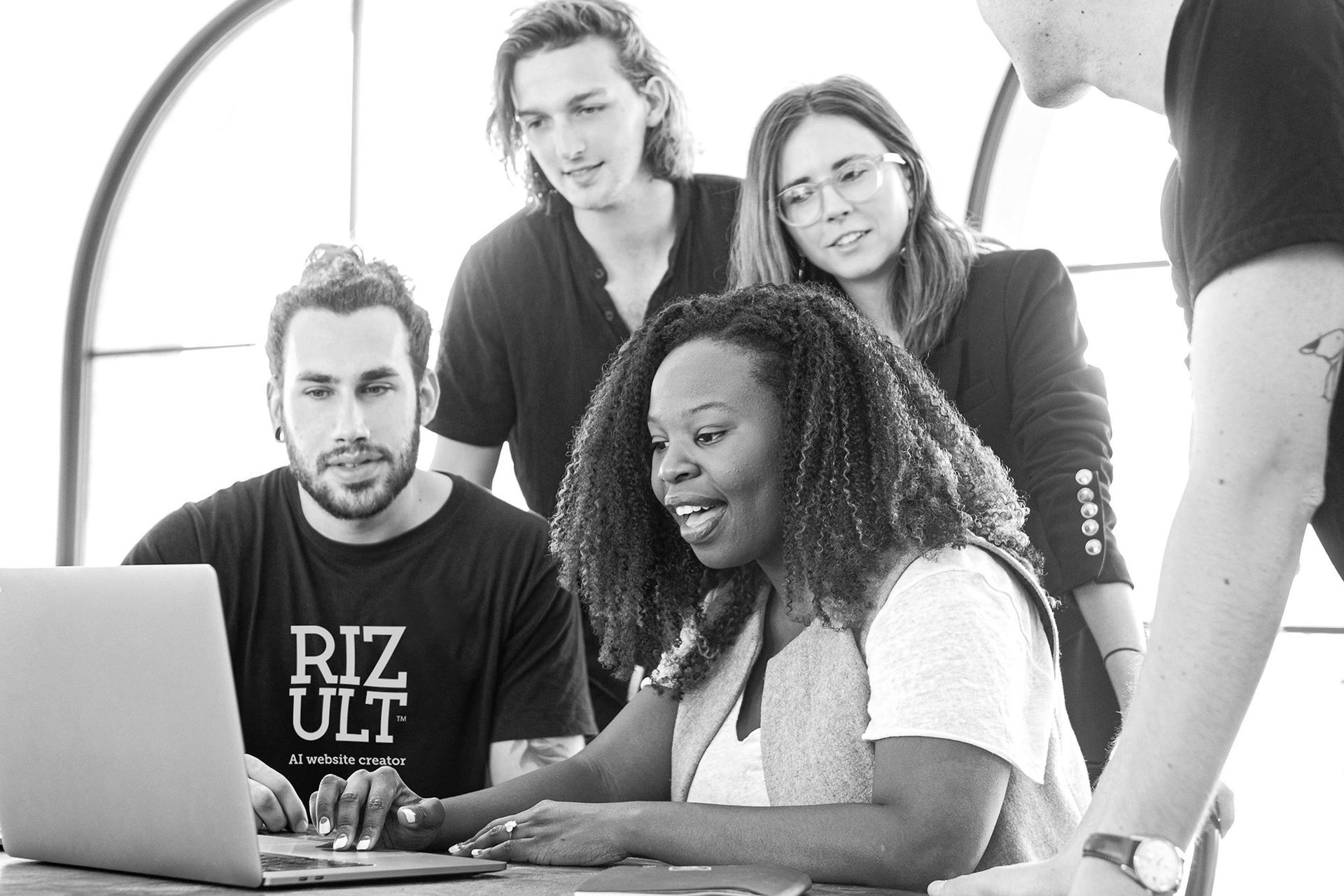 A group of people are looking at a laptop computer.