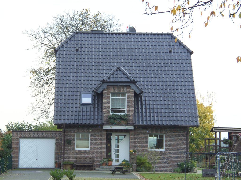 Wohnhaus mit neu gedecktem anthrazitfarbenem Dach.