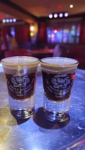 Hay dos vasos de chupito con una serpiente encima sobre una mesa.