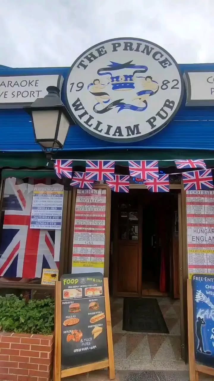 La entrada al pub Prince William con banderas británicas.