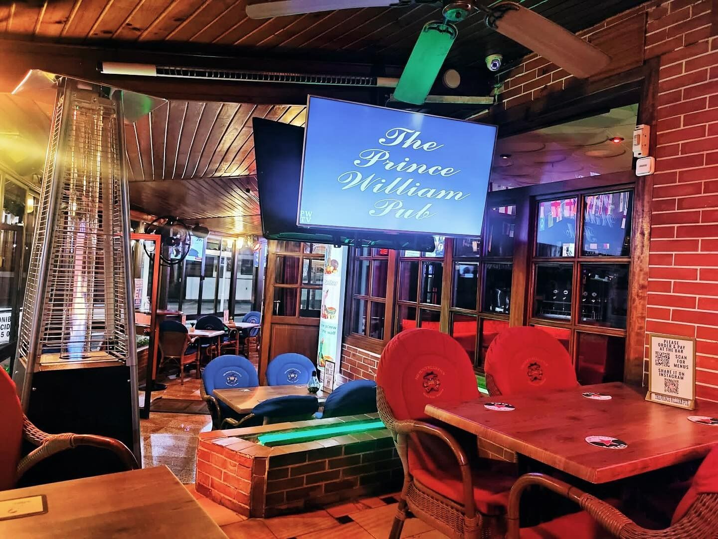 Un restaurante con mesas y sillas y un cartel que dice 