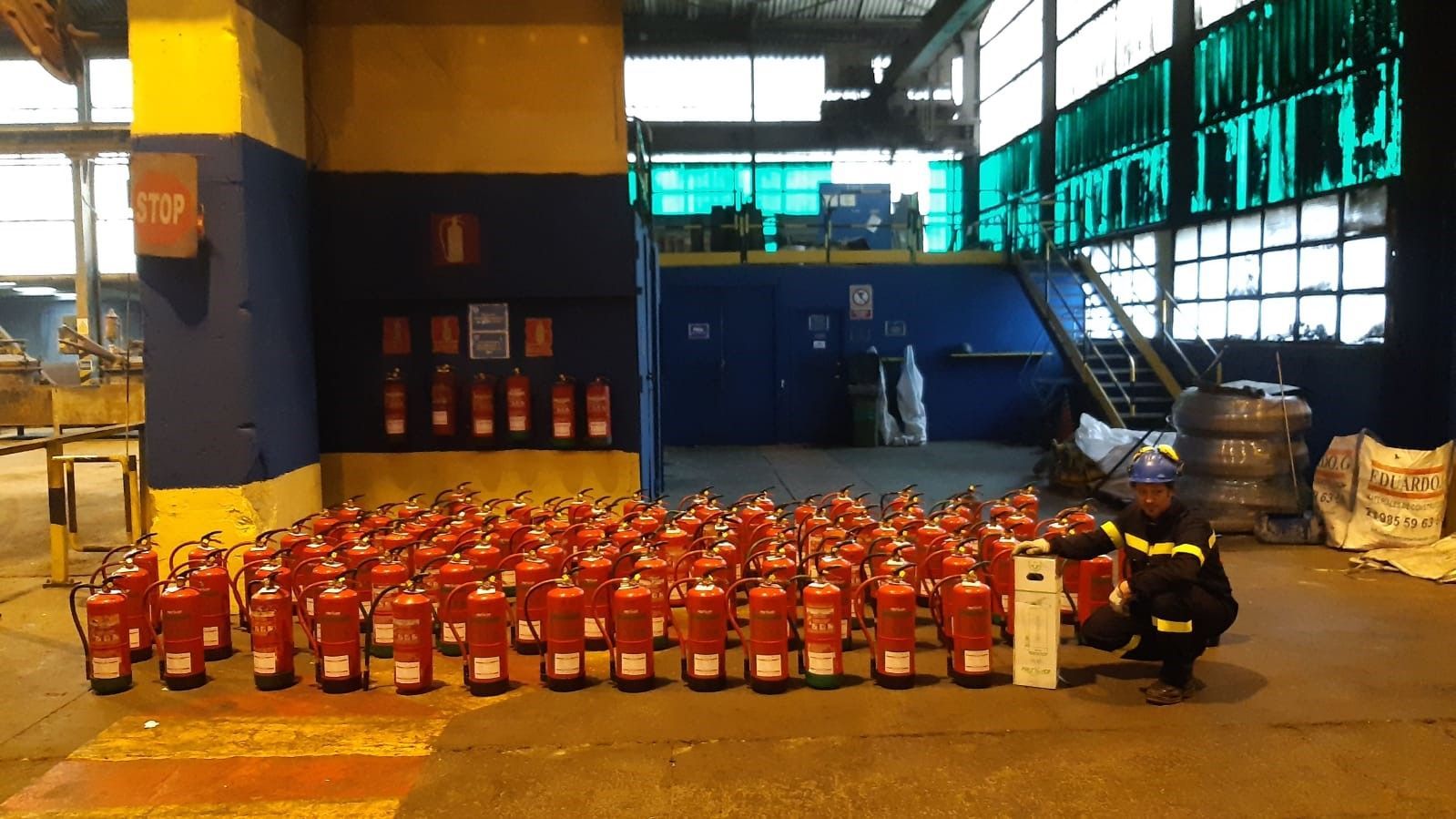 Un montón de extintores están alineados en un almacén.