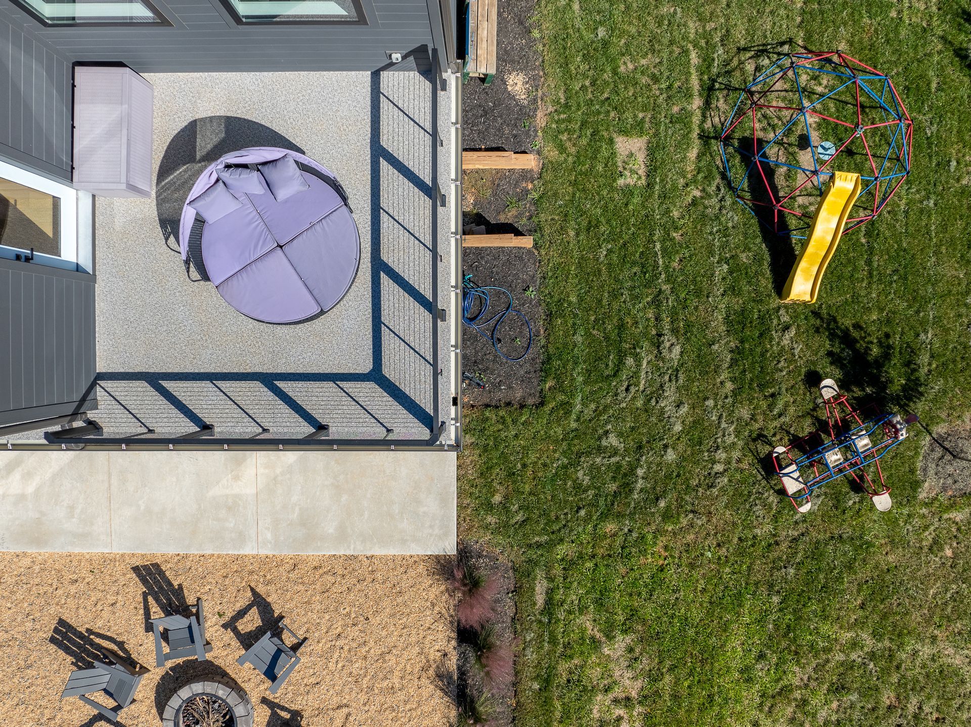 An aerial view of a backyard with a deck and a playground.