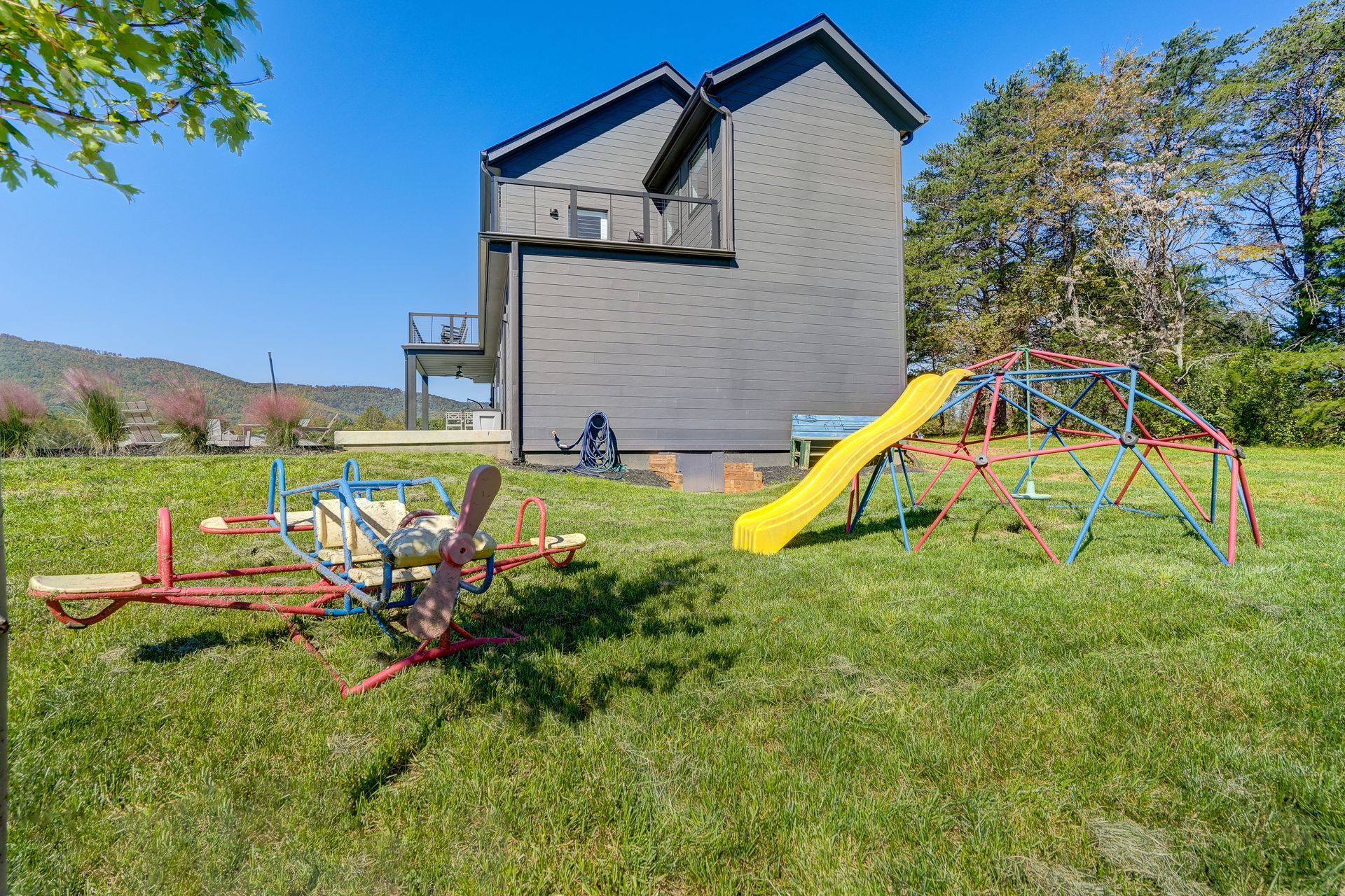 A house with a playground in front of it.