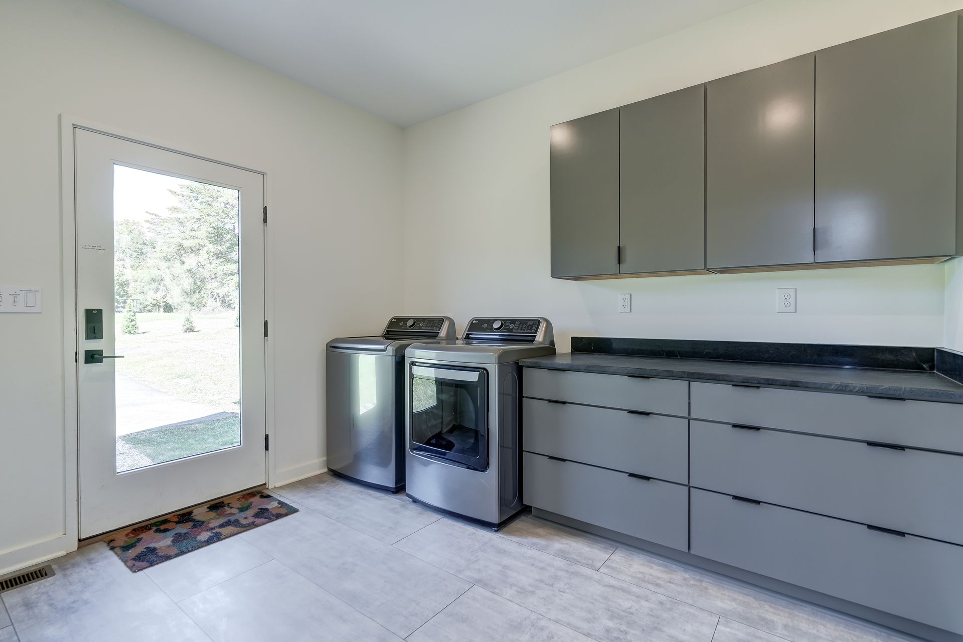 A laundry room with a washer and dryer and a window.