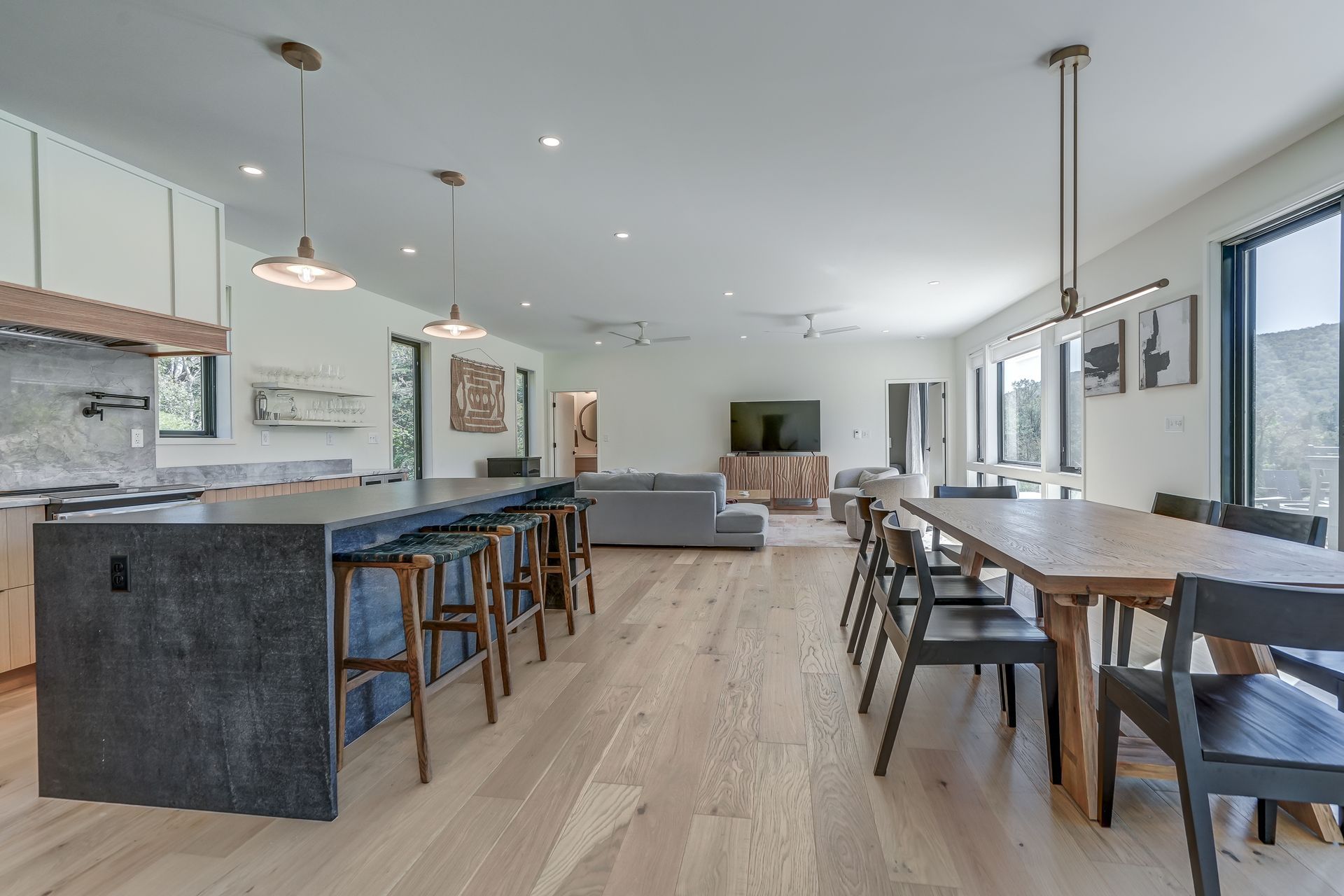 A kitchen , dining room , and living room with hardwood floors.