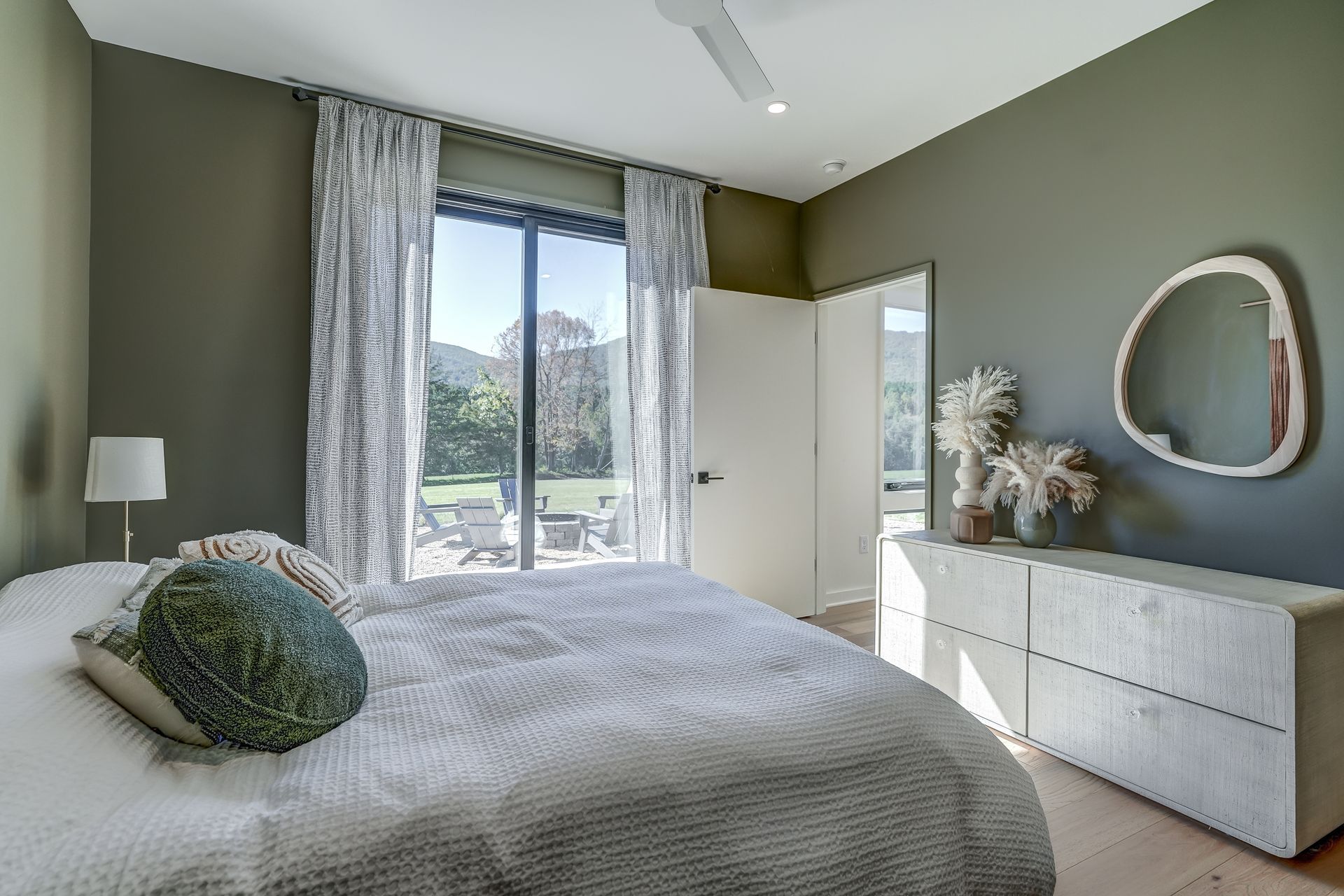 A bedroom with a large bed , dresser and mirror.