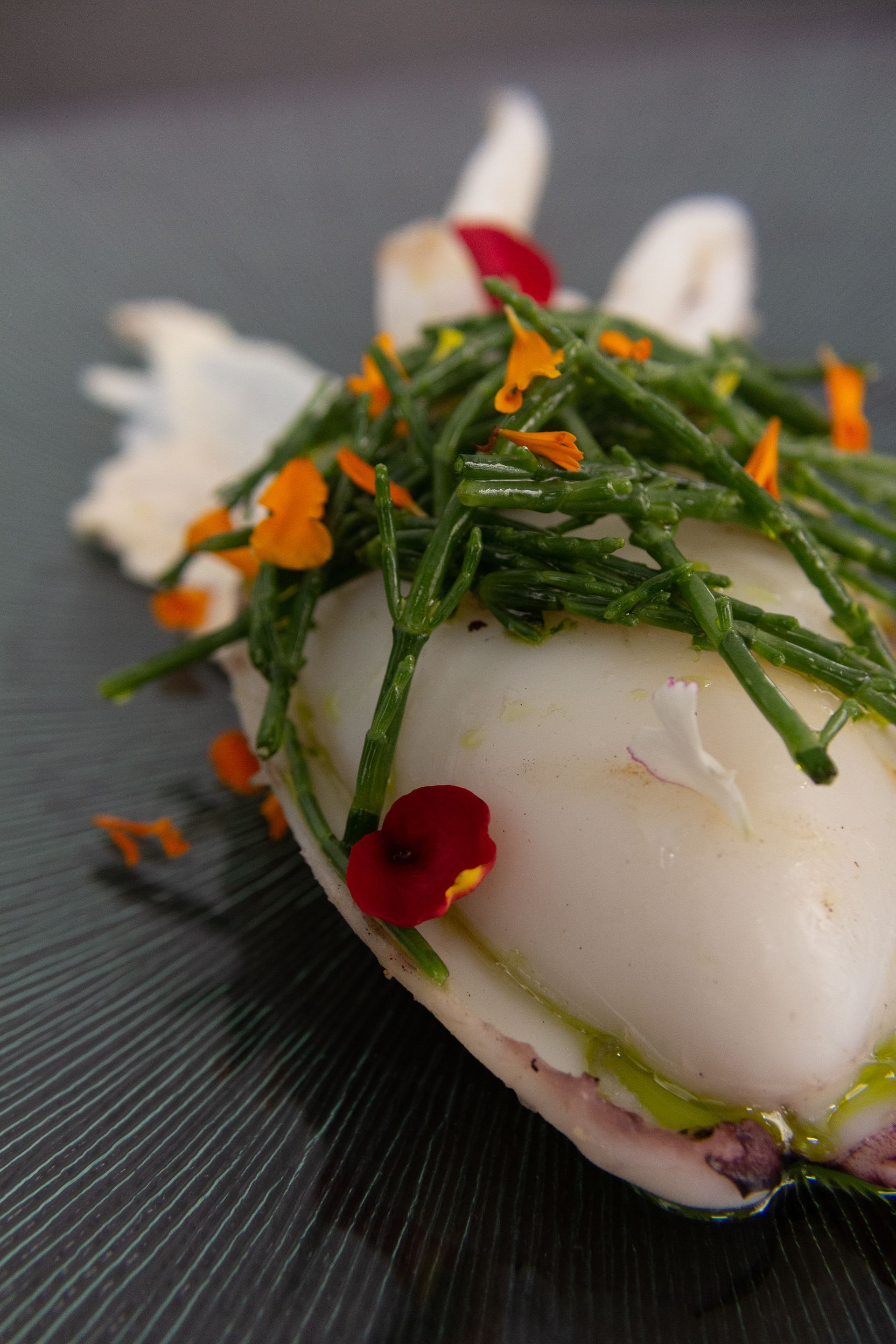 Un primer plano de un plato de comida con flores sobre una mesa.
