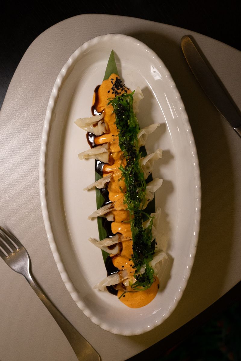 Un plato blanco cubierto con comida y un tenedor sobre una mesa.