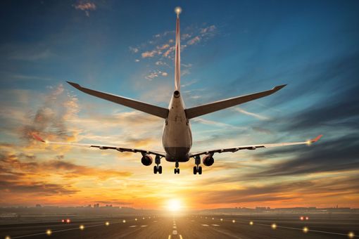 Avion qui décole avec un coucher de soleil