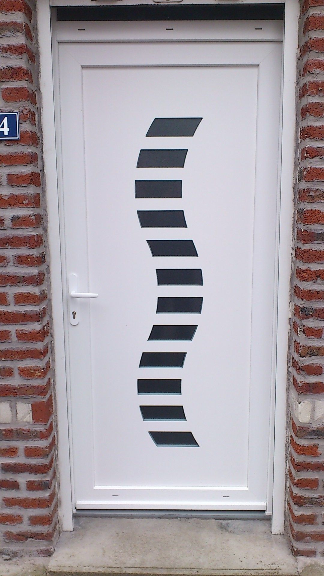 Porte blanche ornée d'un motif en verre noir ondulé.