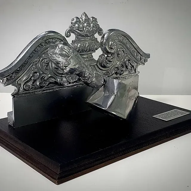 Una estatua de un león está sentada sobre una mesa de madera.