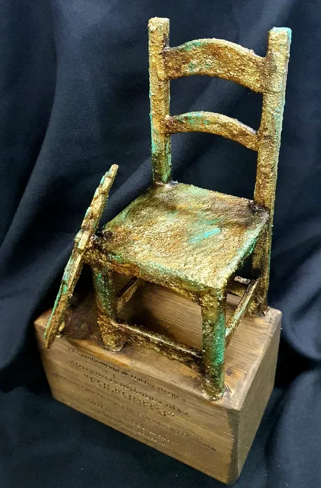 Una estatua de una silla con el asiento roto.