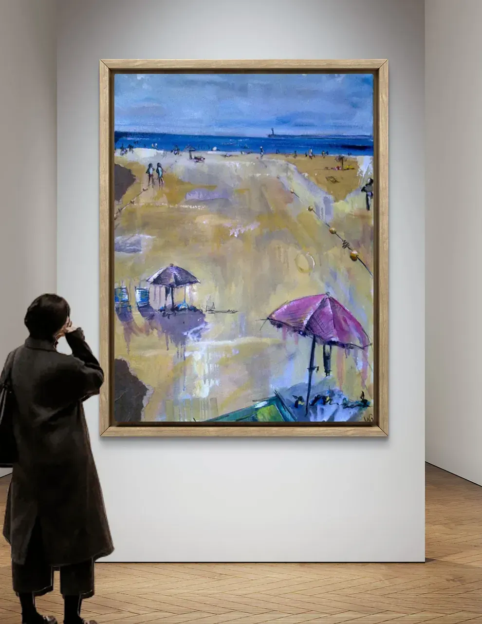 Una mujer mira un cuadro de una playa con sombrillas.
