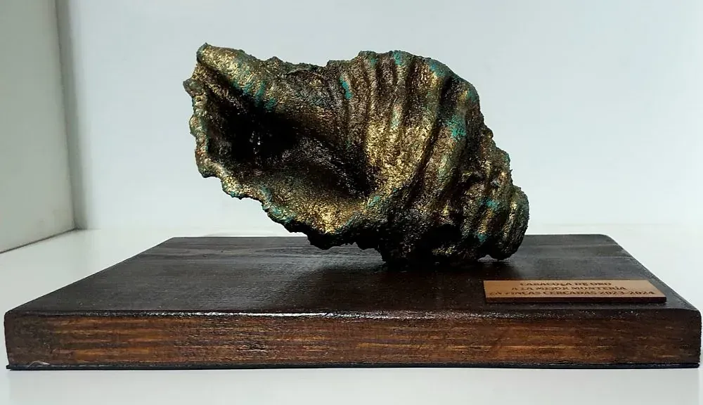 Una estatua de una concha marina está sentada sobre una mesa de madera.