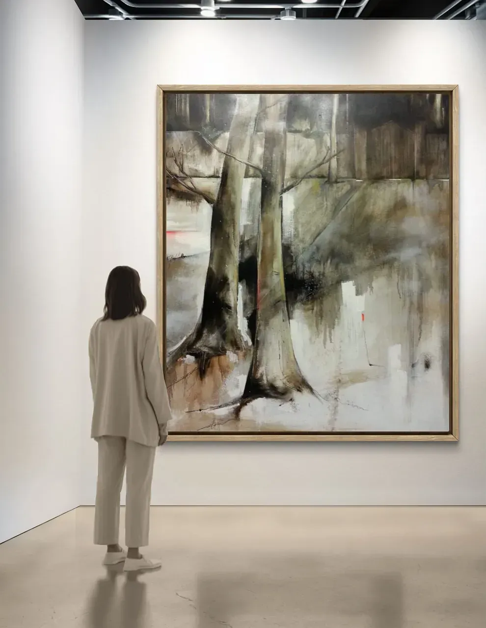 Una mujer está parada frente a un cuadro grande en un museo.