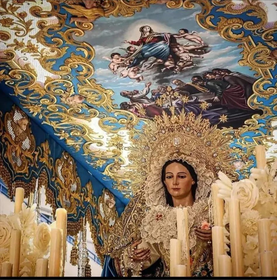 Una estatua de una mujer está rodeada de velas y una pintura en el techo.
