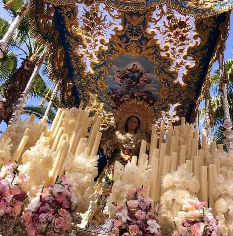 Una estatua de una mujer rodeada de velas y flores.