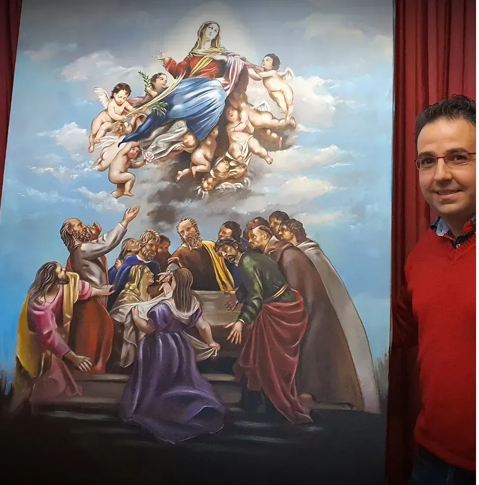 Un hombre está parado frente a una gran pintura de un grupo de personas.