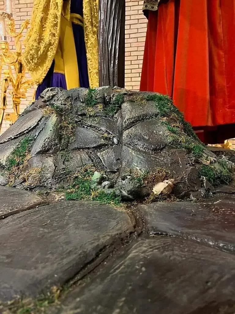 Una estatua de la cara de un hombre está sentada sobre una roca.