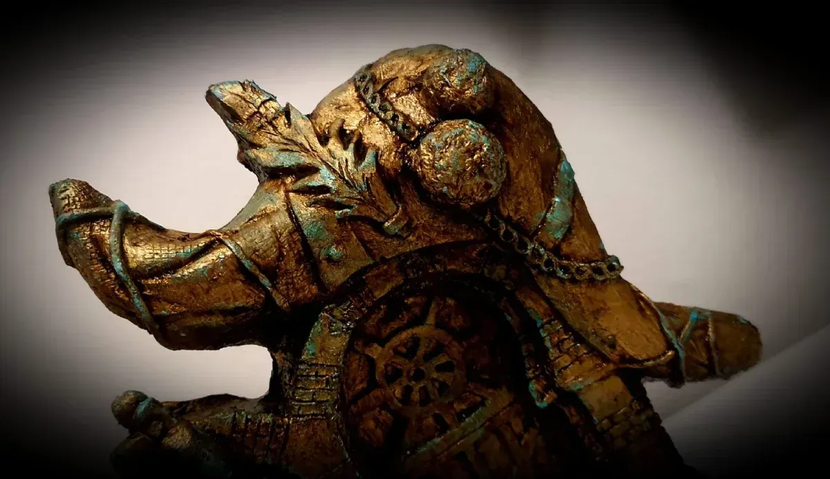 Un primer plano de una estatua de un elefante con una cadena alrededor de su cuello.