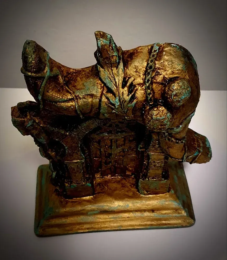 Una estatua de oro con una pluma encima.