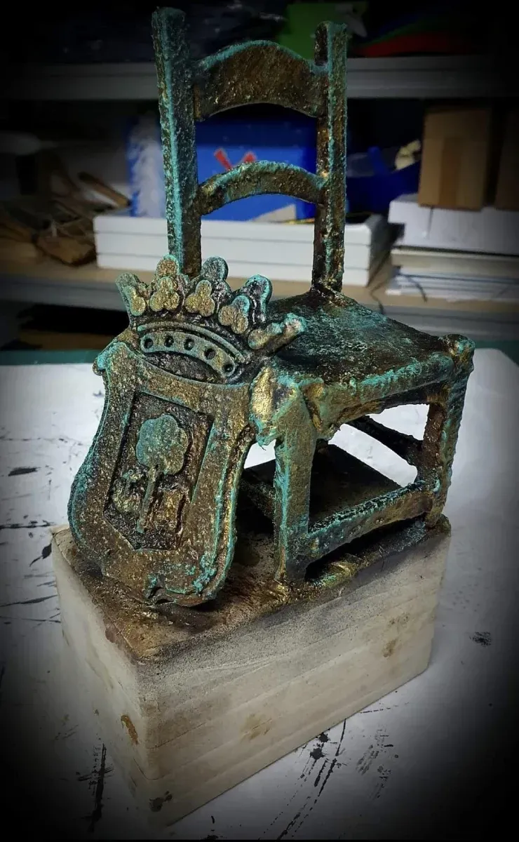 Una estatua de una silla con un escudo de armas en ella.
