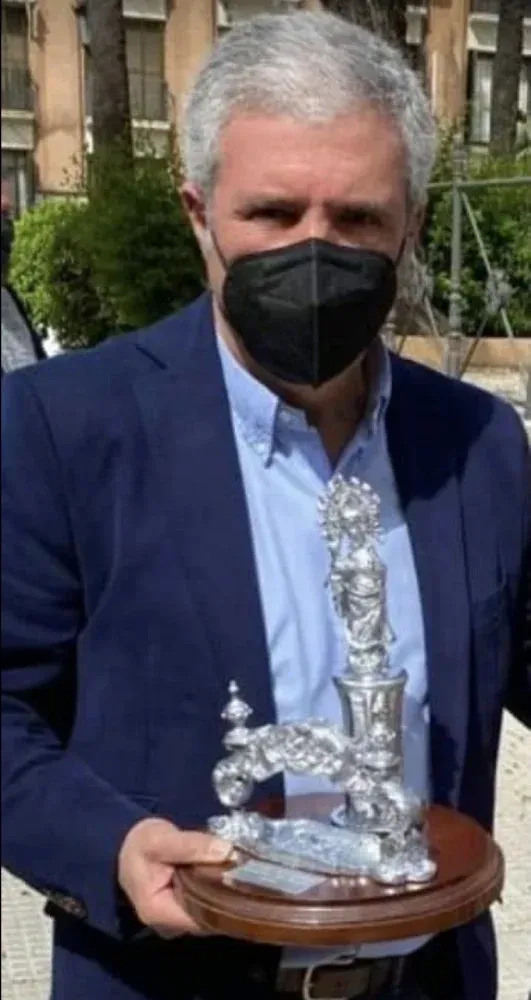 Un hombre que lleva una máscara sostiene un trofeo.