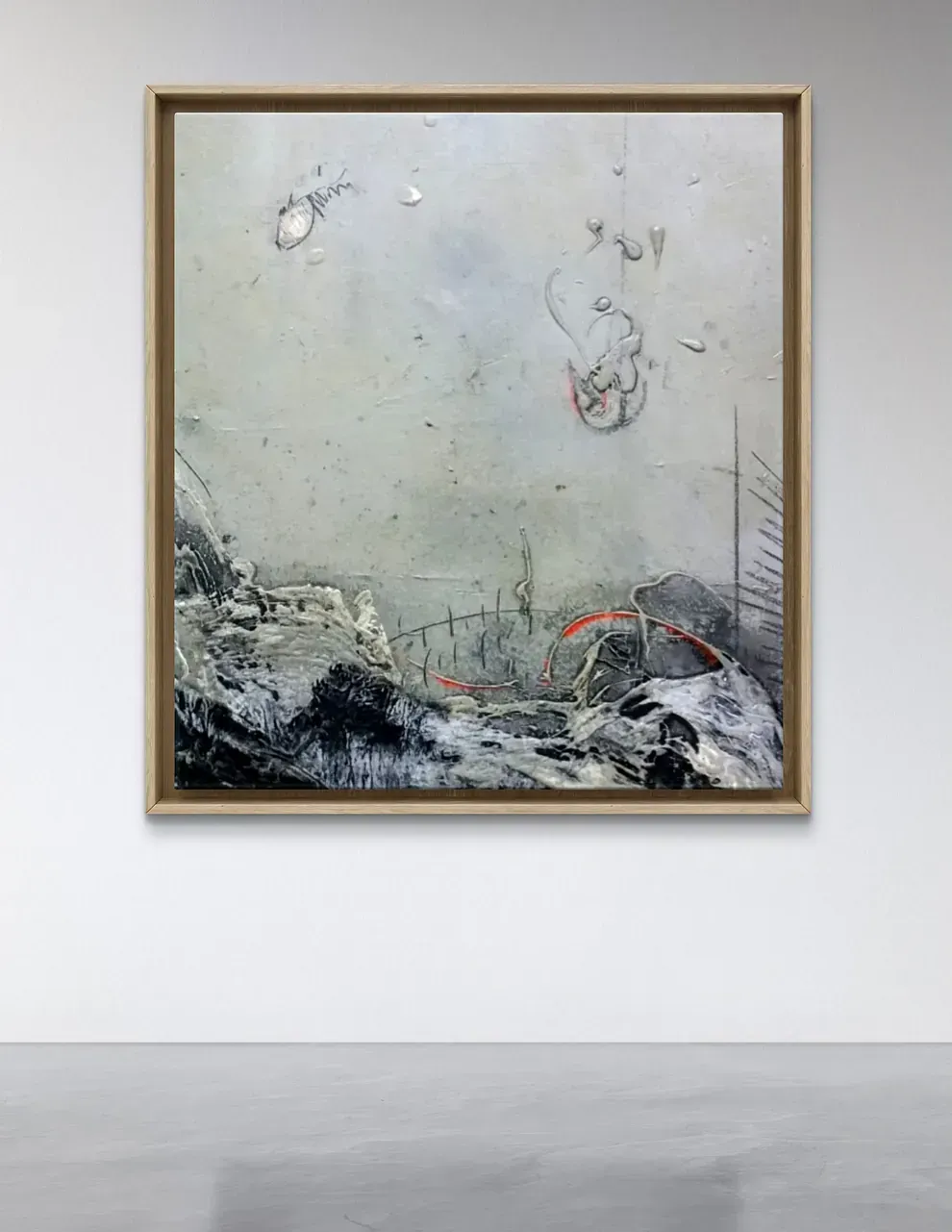 Un cuadro enmarcado está colgado en una pared blanca.