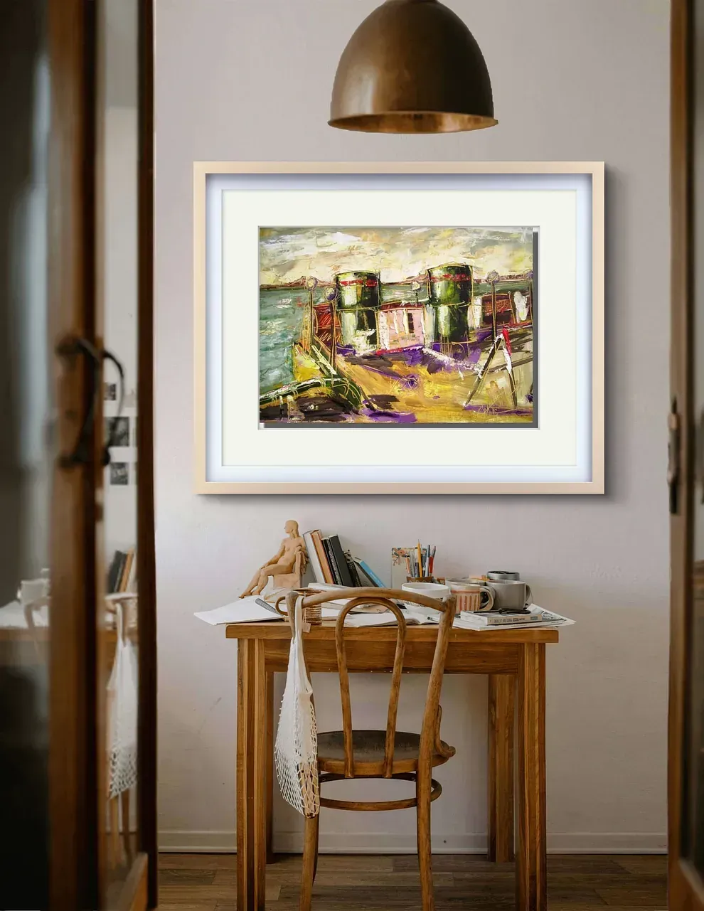 Un cuadro está colgado en una pared encima de un escritorio y una silla.