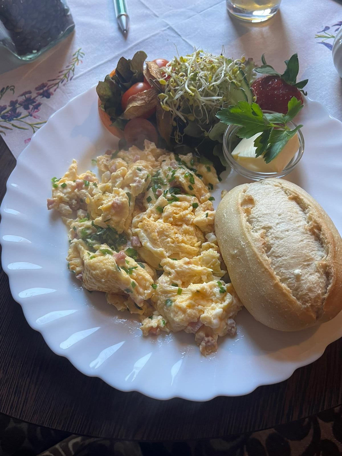 Ein Teller mit Eiern, Brot und Gemüse auf einem Tisch.