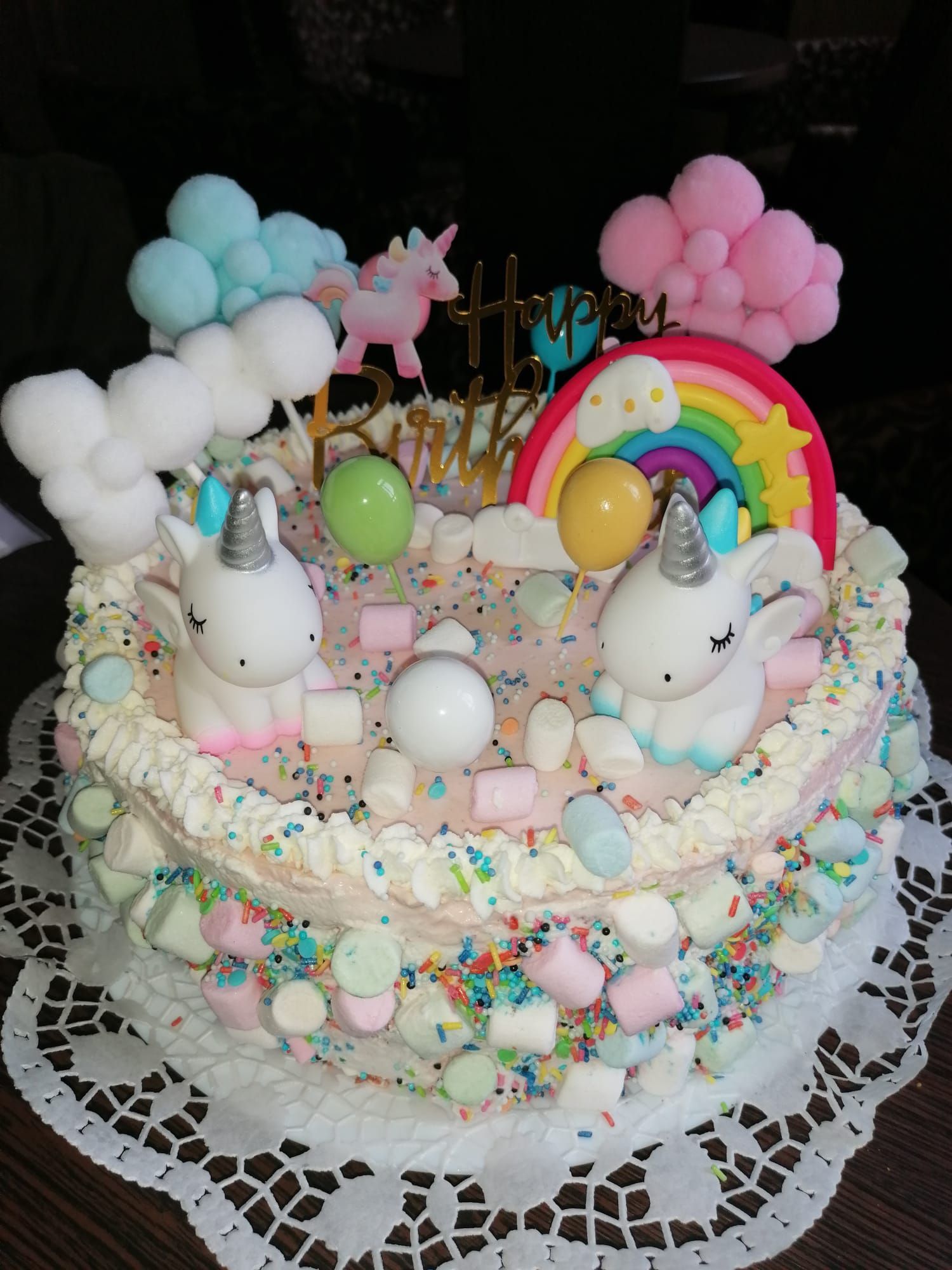 Eine Geburtstagstorte mit Einhörnern und einem Regenbogen darauf