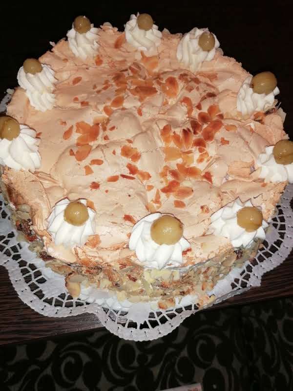 Ein Kuchen mit Schlagsahne und Oliven obenauf