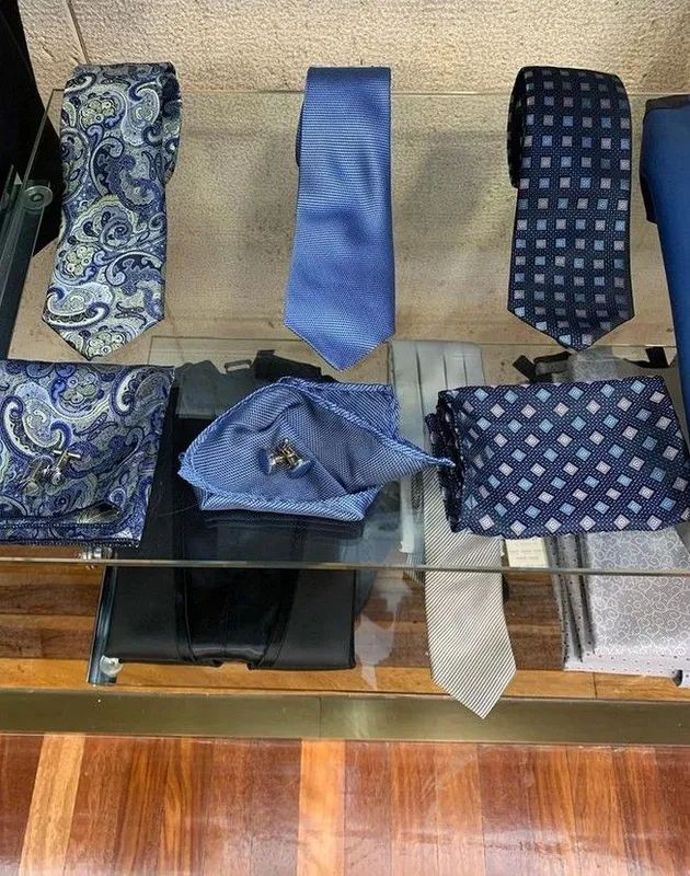 Vitrina con corbatas y pañuelos de bolsillo azules en varios estampados.