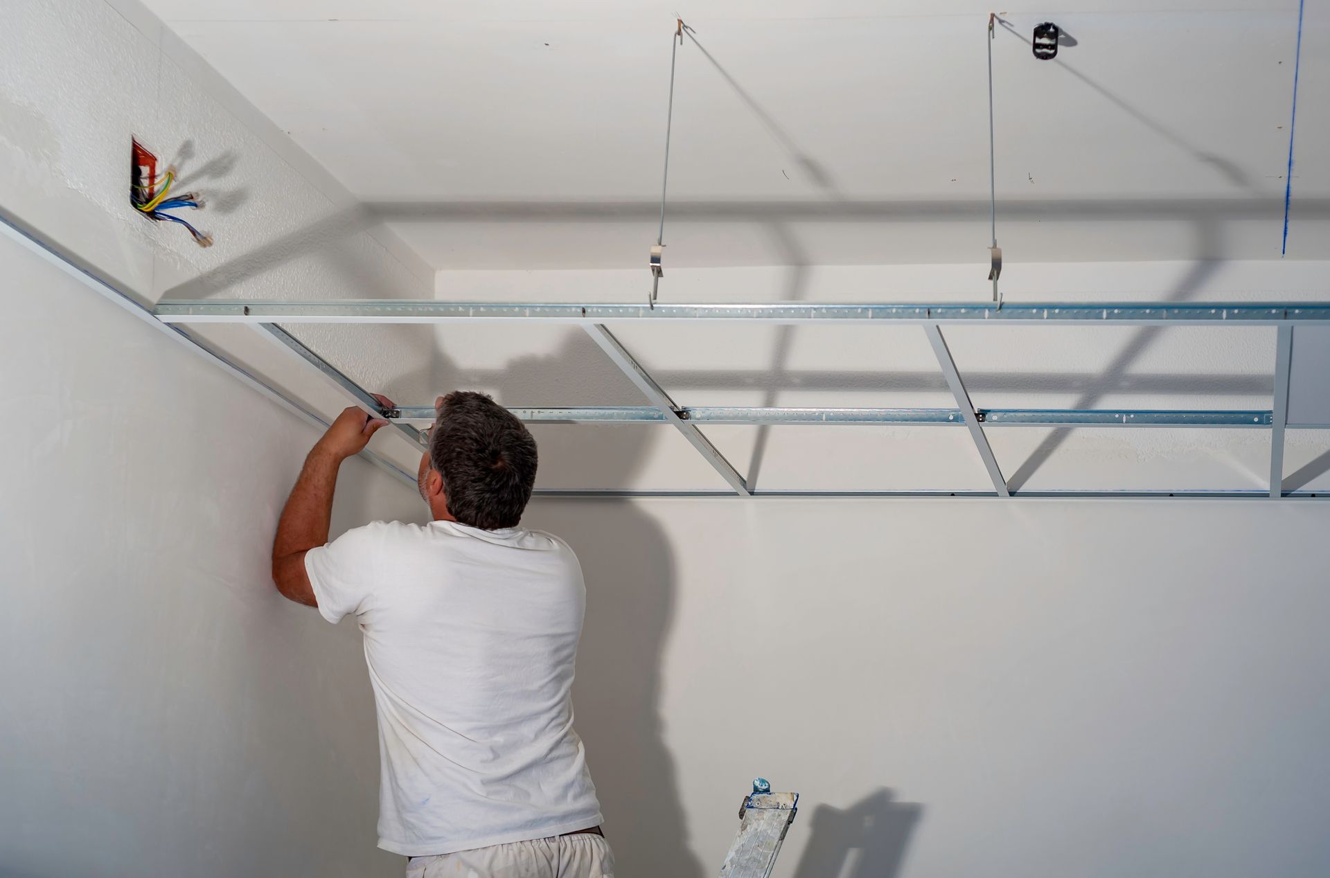 Ouvrier installant un calepinage de faux plafond