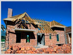 Se está construyendo una casa de ladrillo con techo de madera.