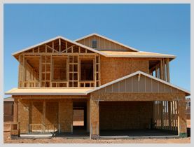 Una casa que se está construyendo con un cielo azul de fondo.
