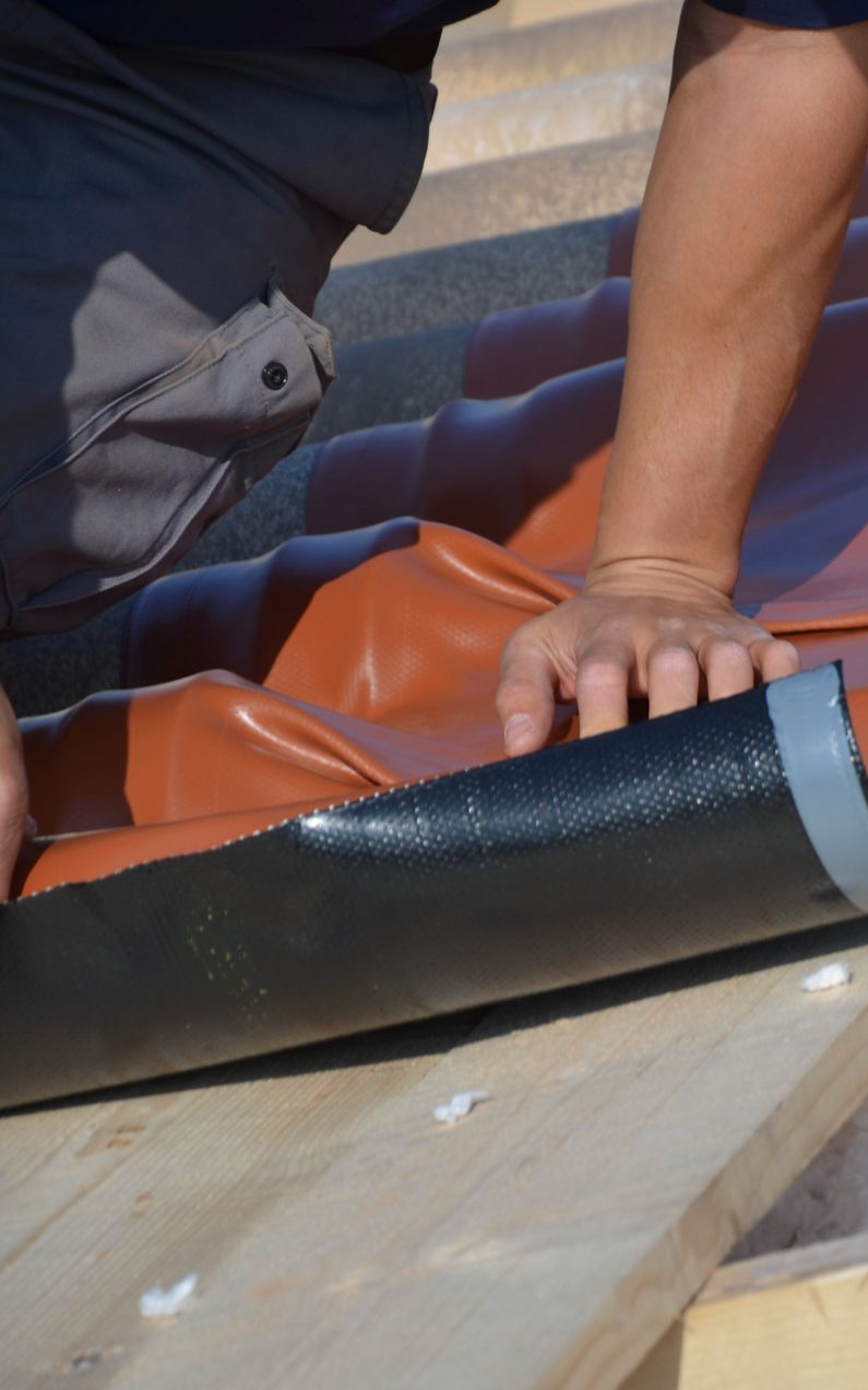 Homme qui procède à l'isolation sous la toiture