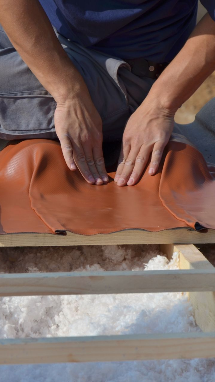 Homme qui procède à une isolation sous la toiture