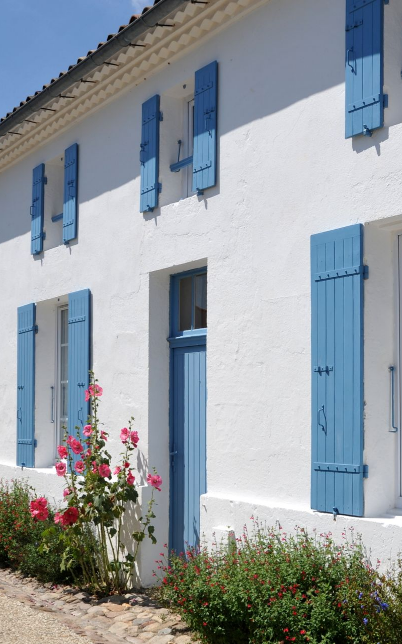 Façade blanche avec menuiseries peintes en bleu