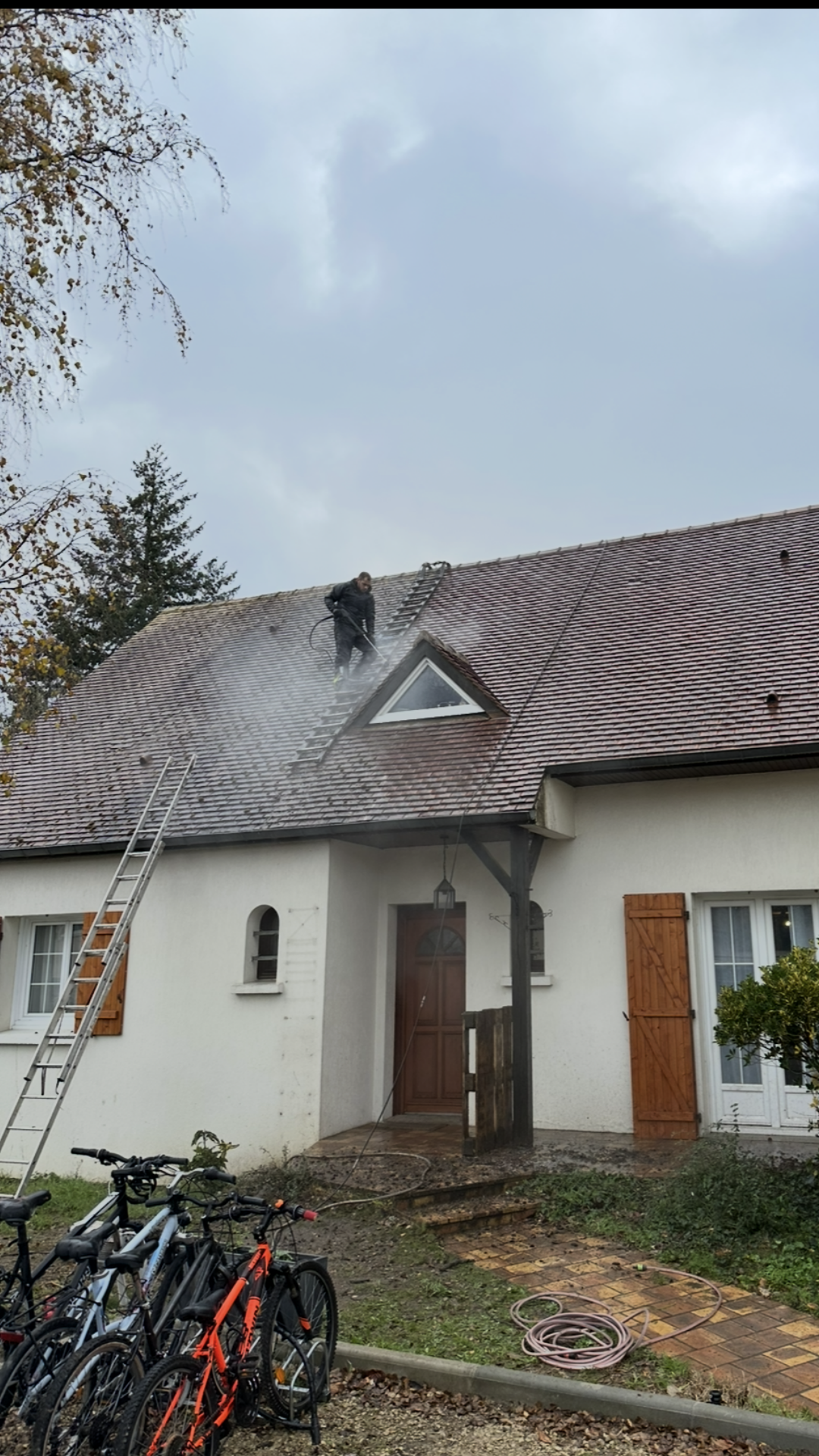 Couvreur qui nettoie une toiture