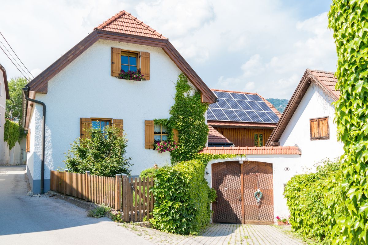 Una casa blanca con paneles solares en el techo.