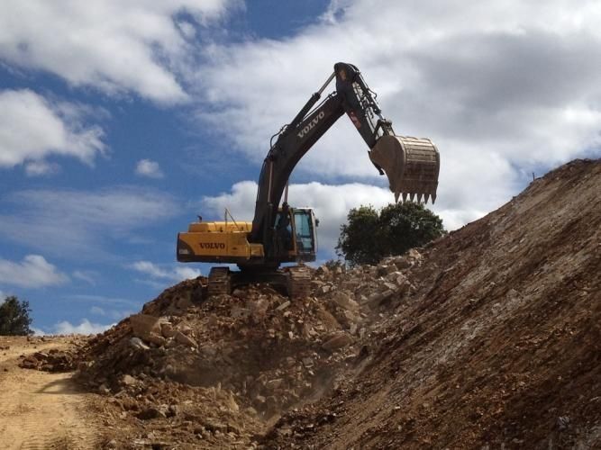Una excavadora Volvo está trabajando en un montón de tierra.