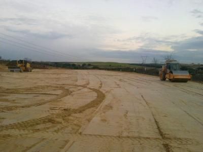 Un par de tractores circulan por un camino de tierra.