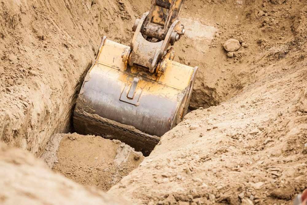 Una excavadora está cavando un hoyo en la tierra.