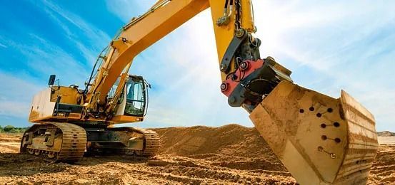 Una excavadora amarilla está cavando un hoyo en la tierra en un sitio de construcción.